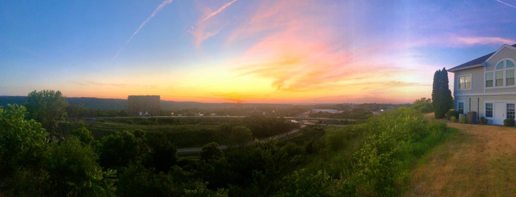 Panorama of a vibrant and colorful sunset over Syracuse, New York from near Syracuse University with Route 81 in the background.
