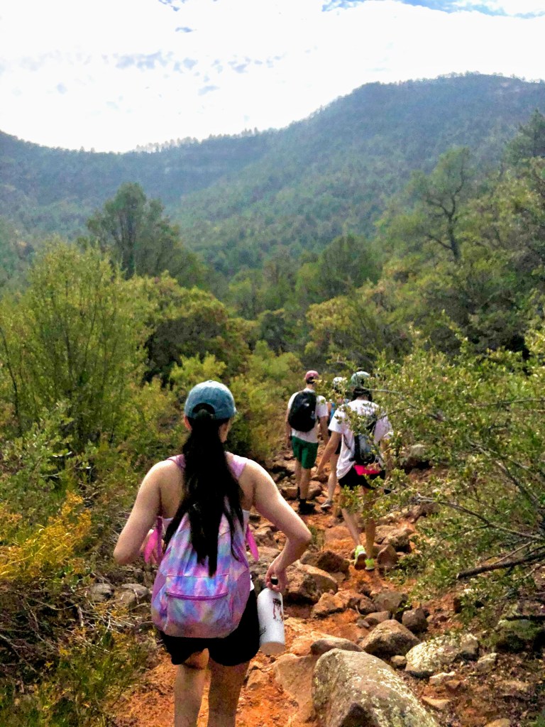 A group of friends hiking 4 miles down to a waterfall on the Bob Bear Trail at Fossil Creek in Strawberry, Arizona