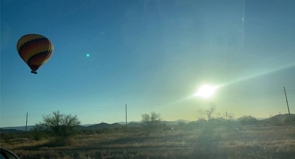 hot air balloon seen on the side of a highway