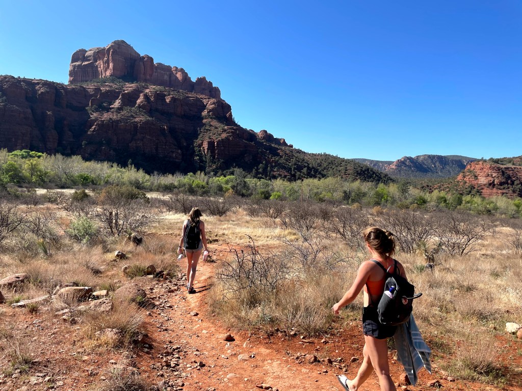 two girls walking through the desert in Sedona, Arizona, on their way to find a swimming hole