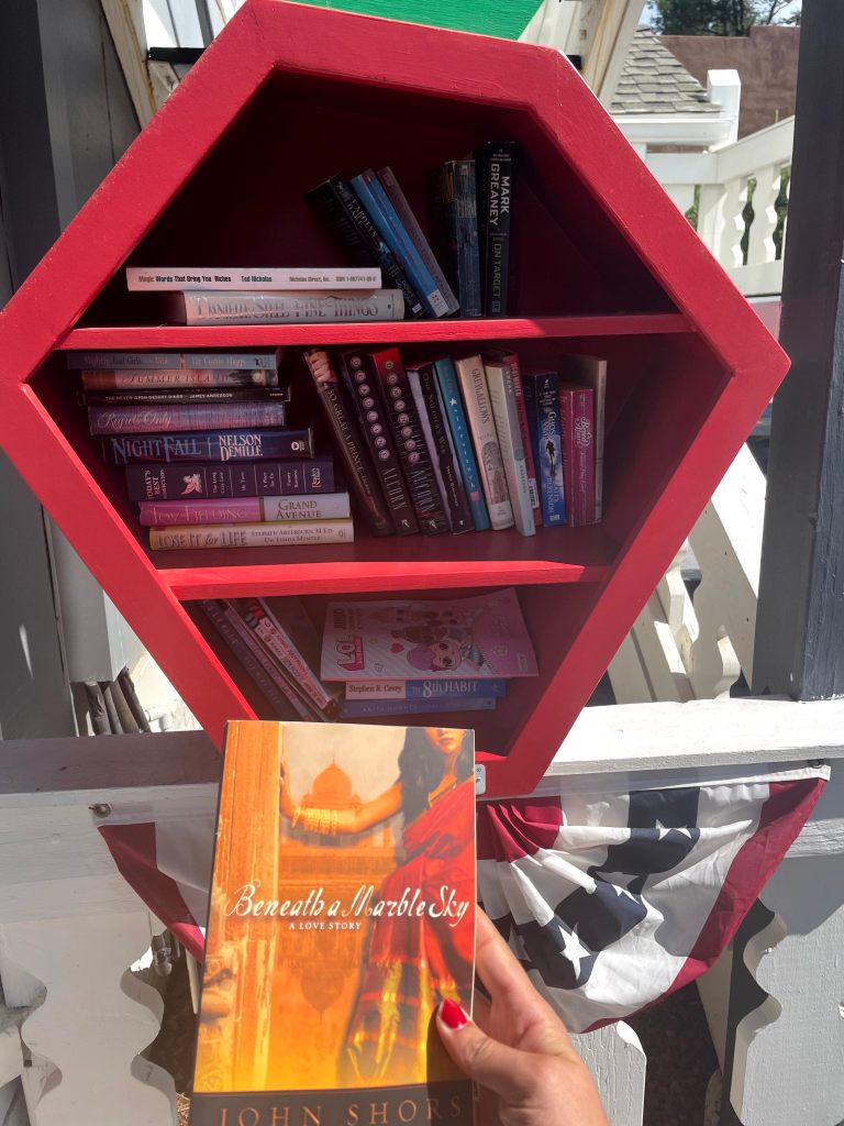 hand holding a romance novel at the community library outside the Strawberry Inn in Strawberry, Arizona