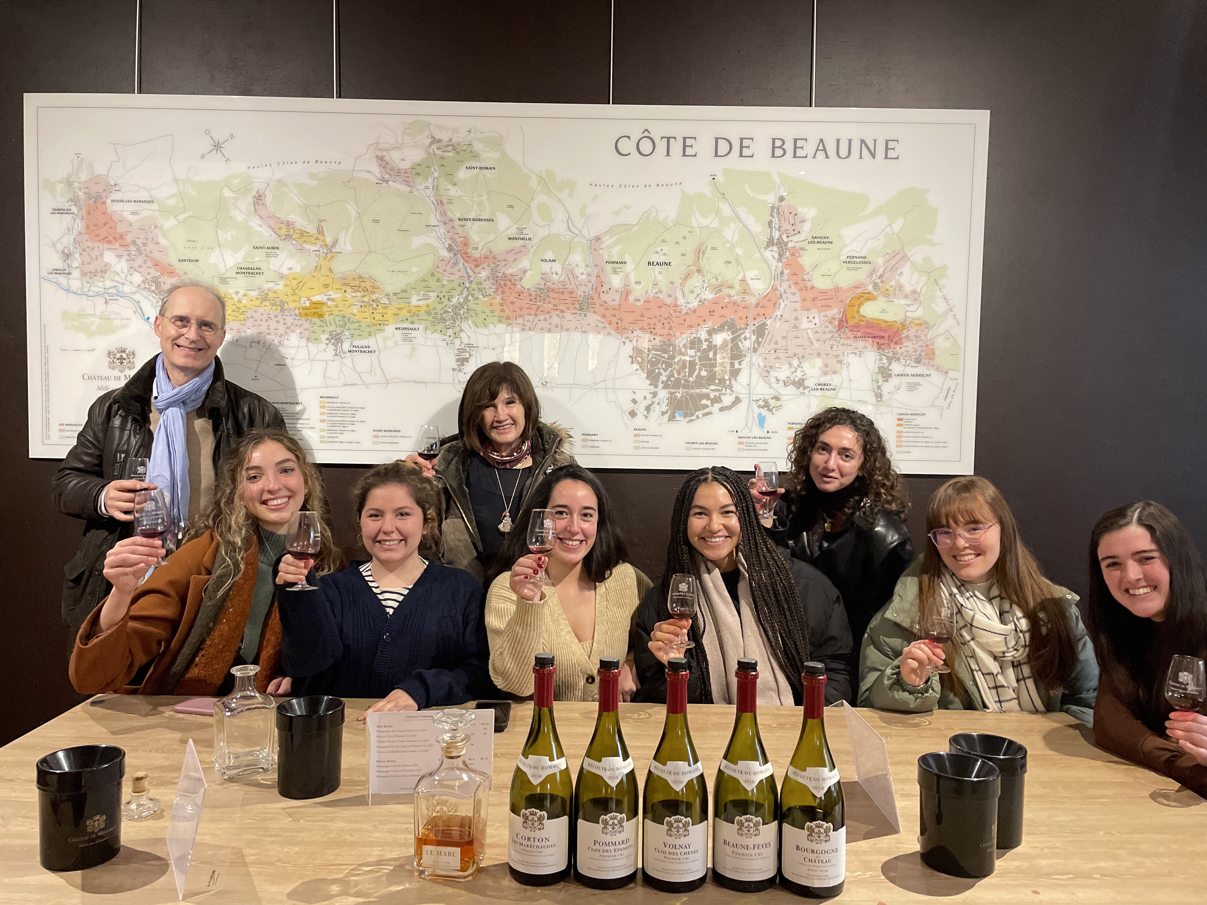 a group of friends holding up their glasses during a wine tasting