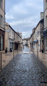 cobblestone streets of Beaune, France, cloudy skies, rain on the streets