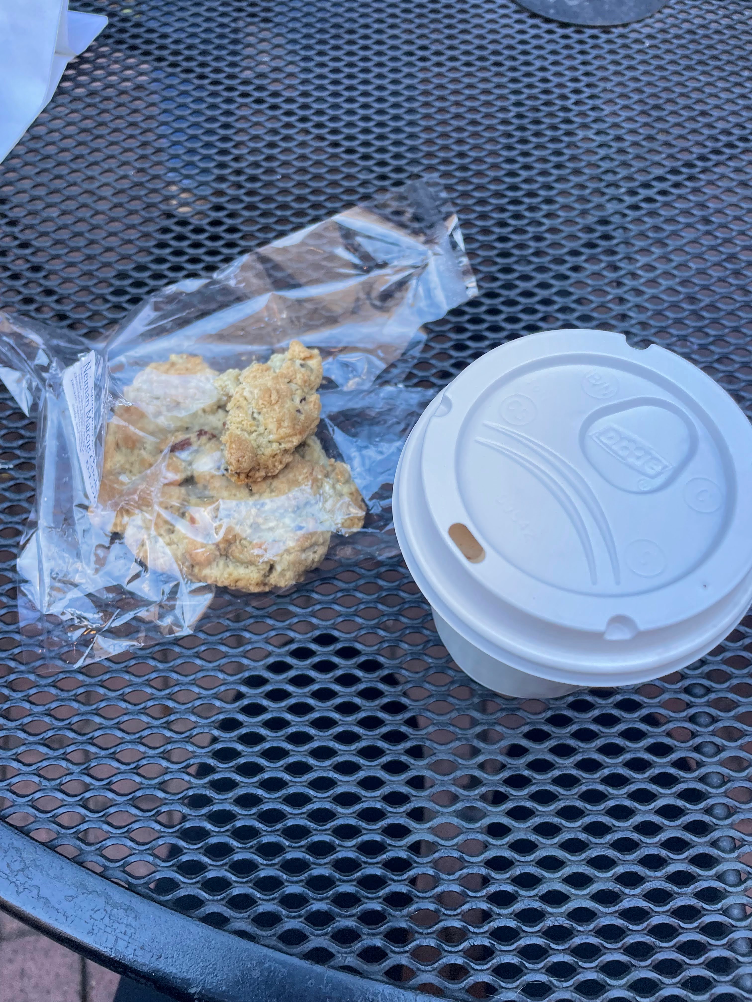 hot pumpkin chai latte to the right of a homemade chocolate chip, oatmeal, and coconut cookie