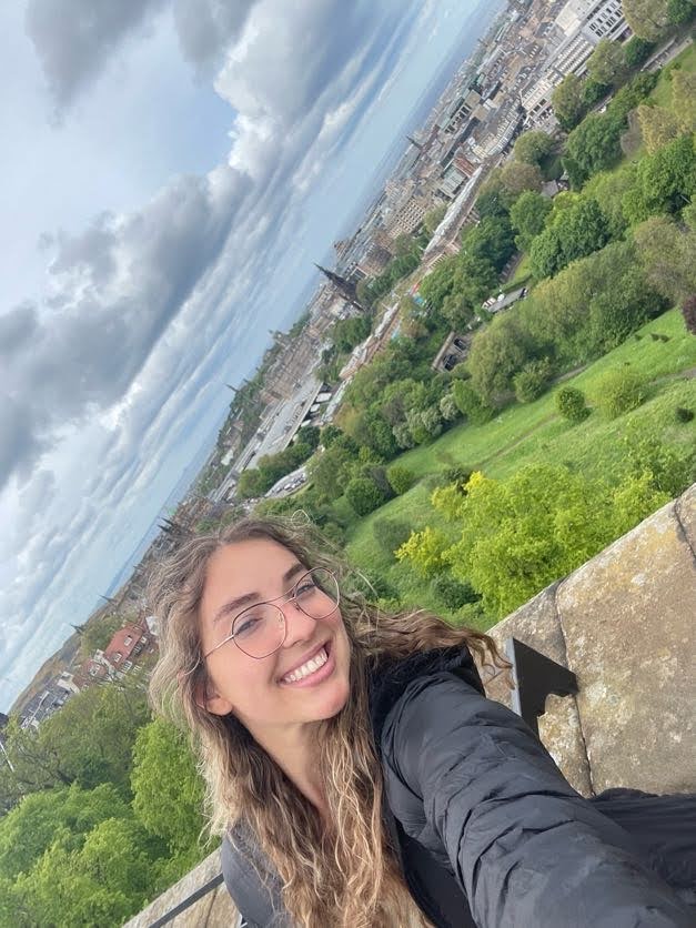 girl taking a selfie at Edinburgh Castle with the North Sea in the background