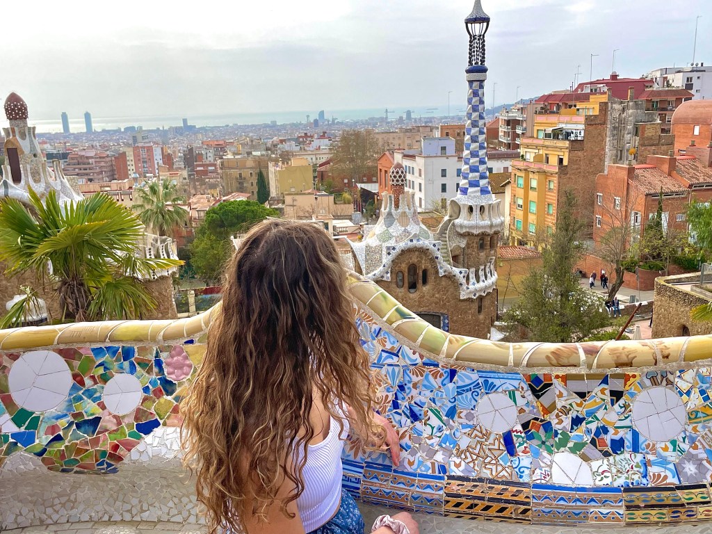 A woman looking out at the ocean from the top of Park Güell in Barcelona