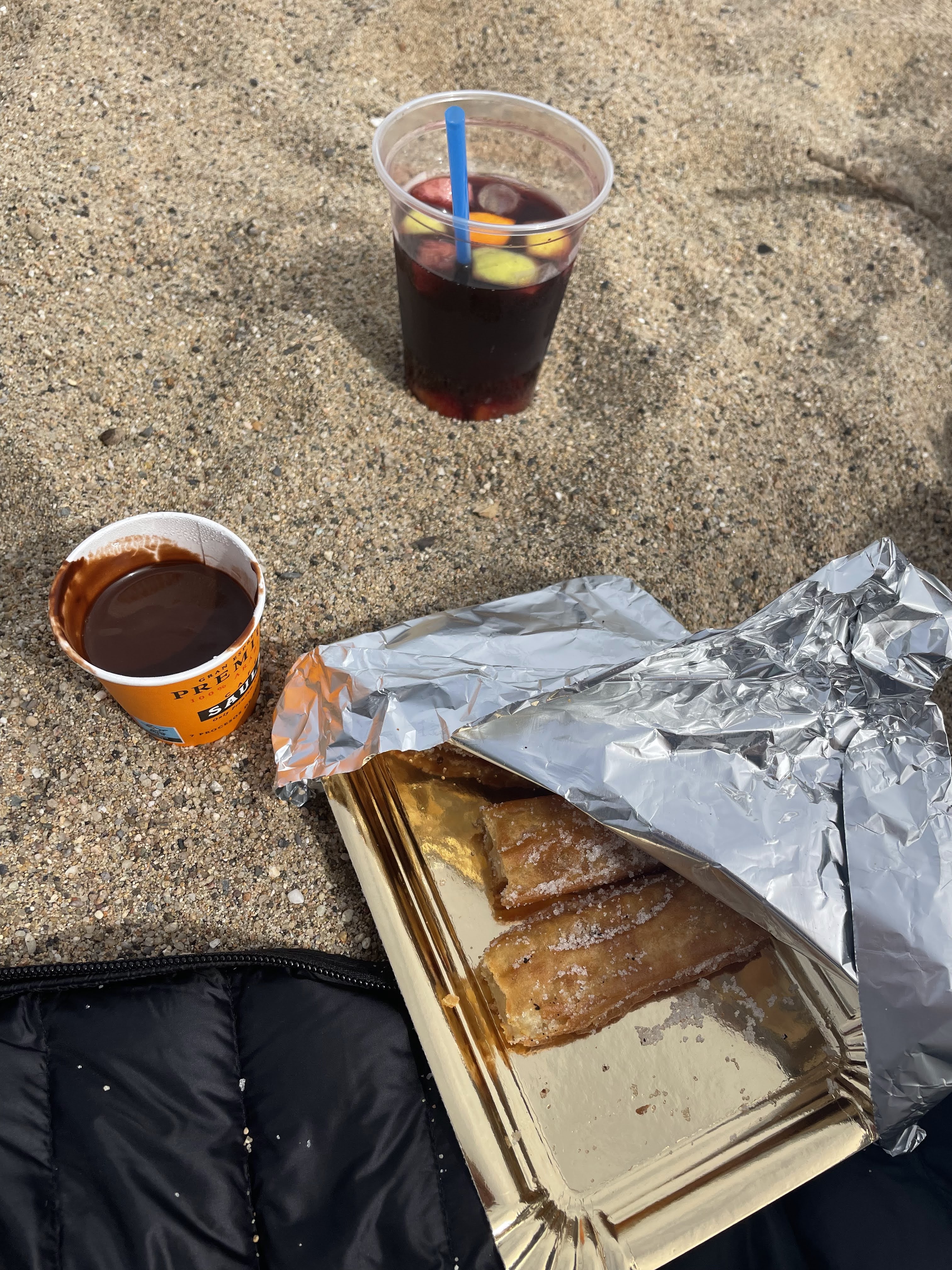 eating churros with chocolate and drinking a sangria on the beach in Spain