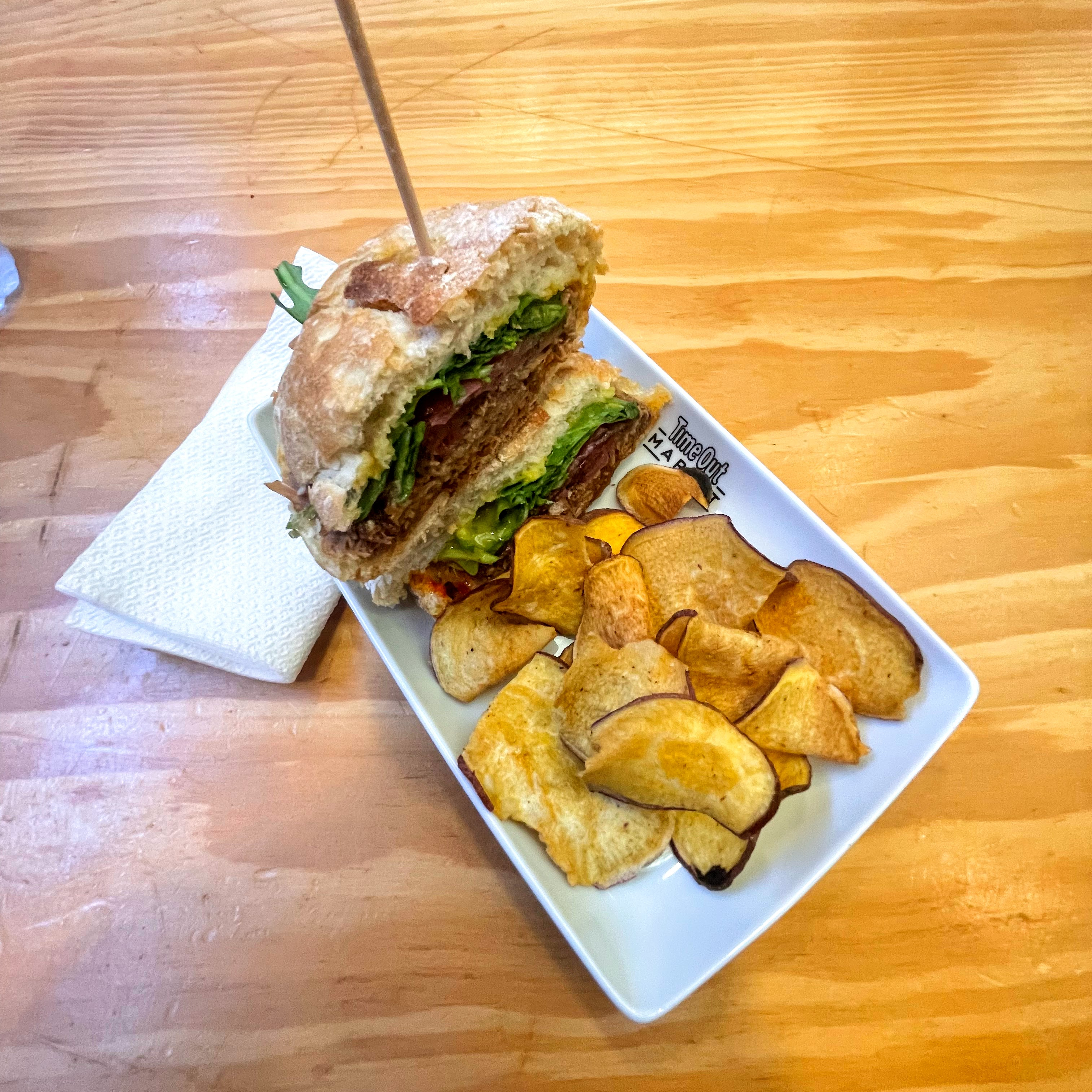 Classic Portuguese bifana sandwich from Time Out Market in Lisbon, Portugal on a plate with a side of chips