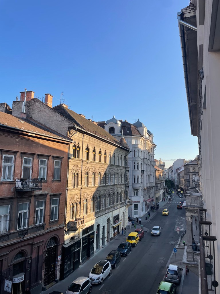 The view of the street down below from an apartment in Budapest, Hungary, during golden hour.
