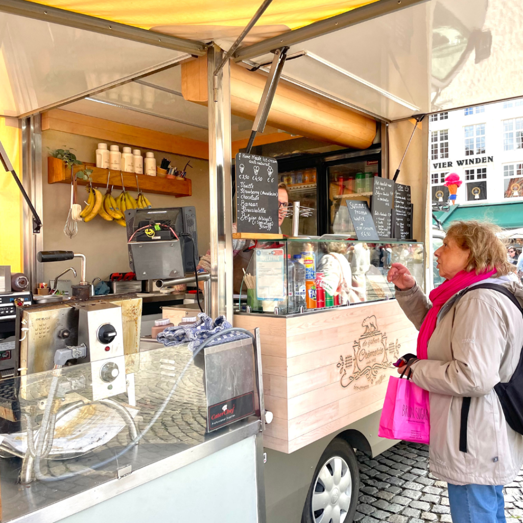 A woman ordering at a classic waffle food truck in Bruges, Belgium