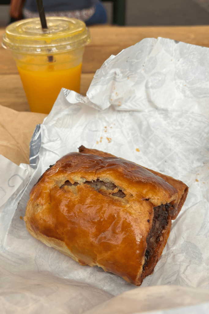 The famous sausage roll from Borough Market in London, England, perfectly baked to a golden pastry dough exterior and filled with a thick portion of heavenly sausage.