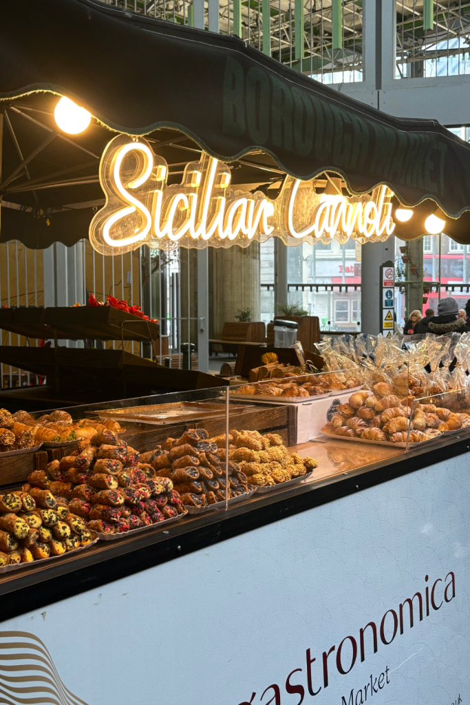 A beautiful and modern Italian dessert stand at Borough Market in London, England displaying a wide variety of flavors of mini canolis.