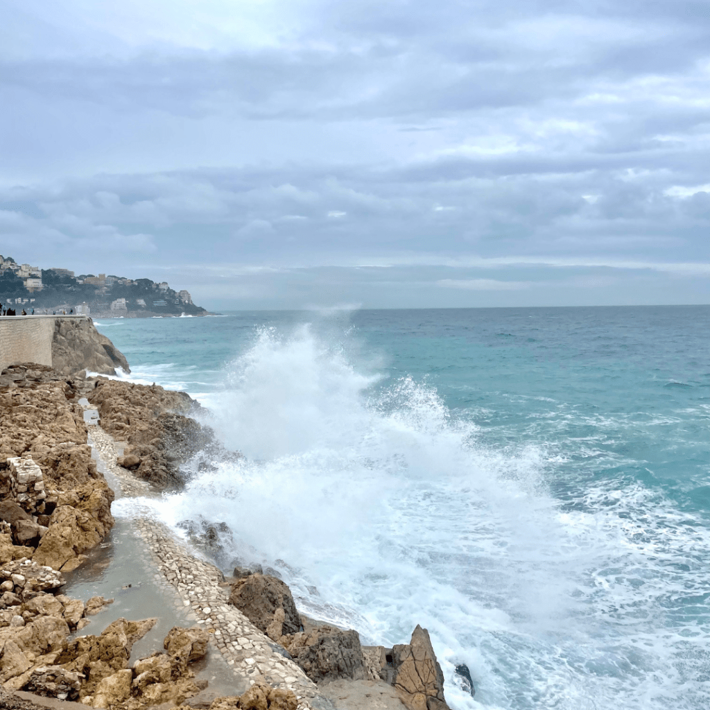 Huge waves crashing into the coast at Promenade des Anglais in Nice, France, on a cloudy and rainy day.