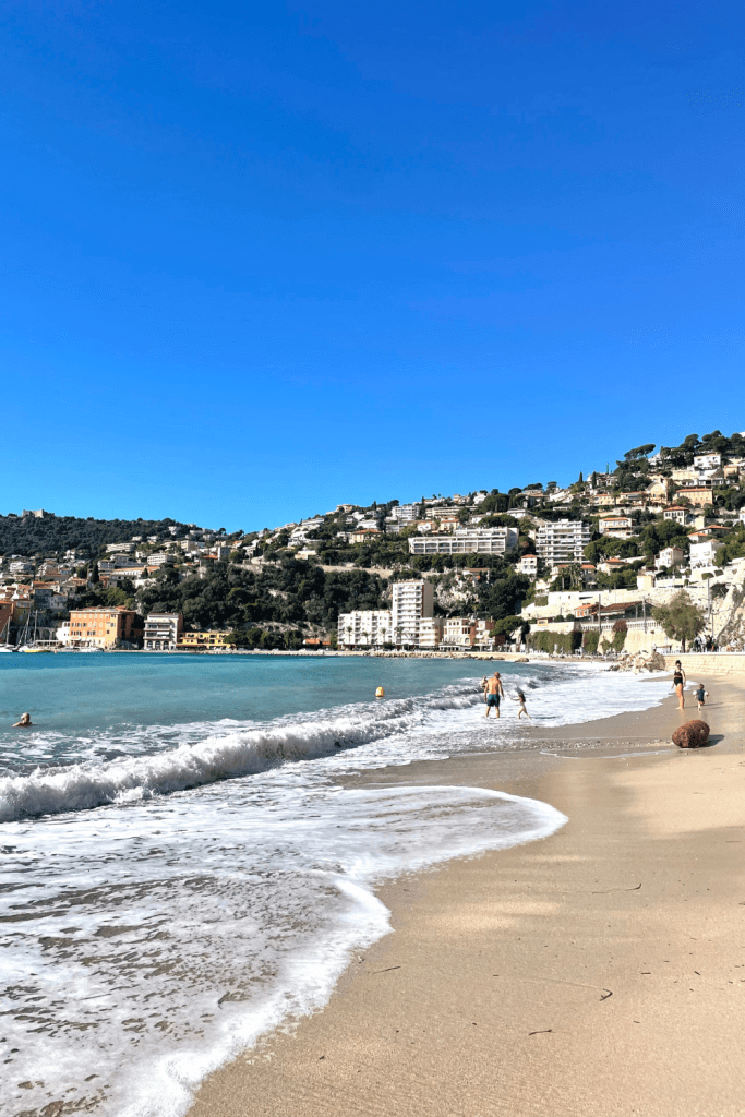 Turquoise blue waves crashing in at Plage Les Bains De la Plage in Villefranche sur Mer on a sunny day in October in the south of France