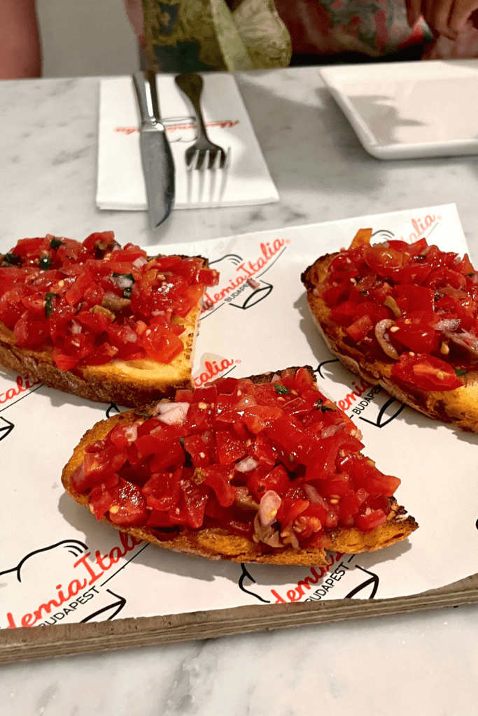 Three pieces of bruschetta topped with diced tomatoes at an amazing Italian restaurant in Budapest, Hungary