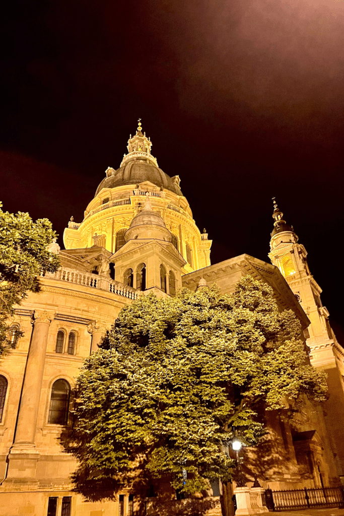 A gorgeous building of gothic architecture lit up at night in Budapest, Hungary
