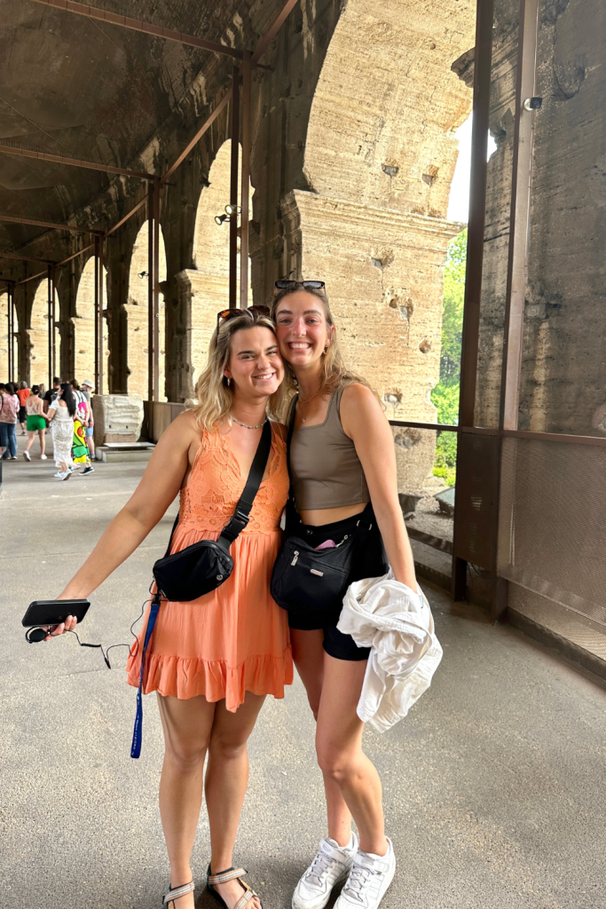Two best friends full of joy after reuniting in the Roman Colosseum in Rome, Italy while on separate trips travelling in Europe.
