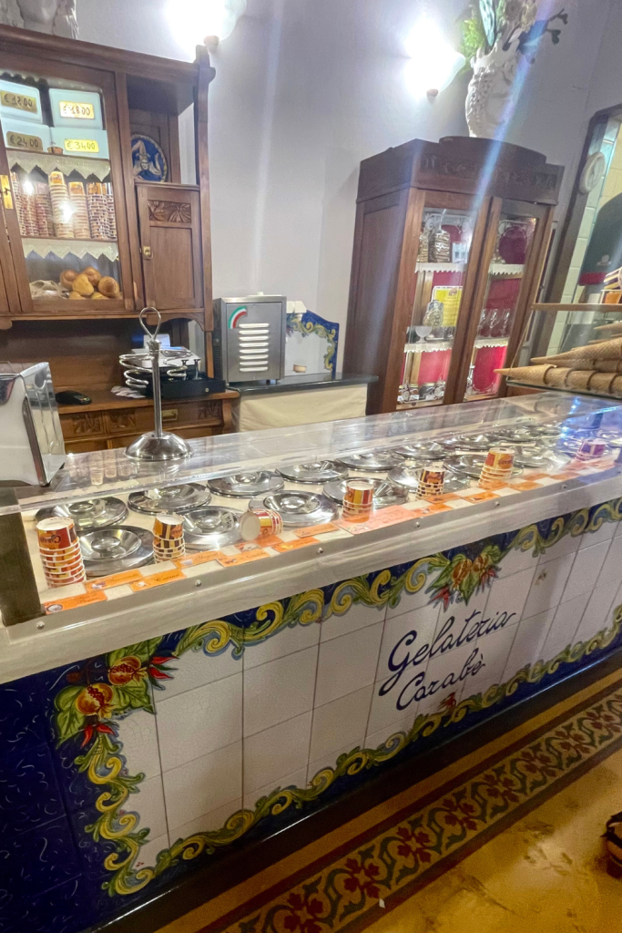 The inside of a classic gelateria in Florence, Italy, showing the bar with all of the gelato flavors