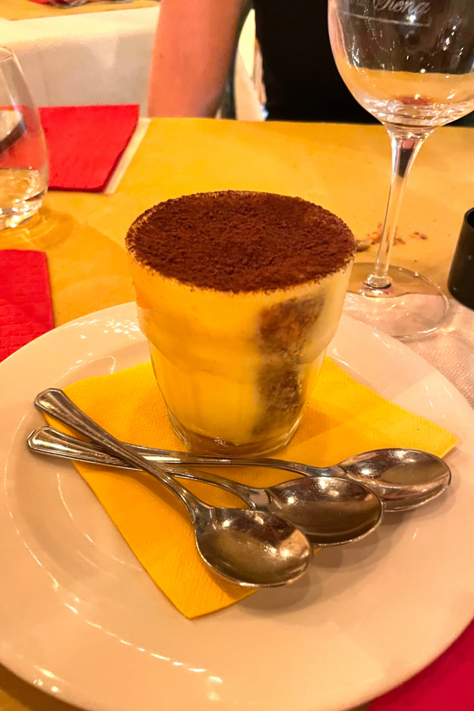 Tiramisu in a glass topped with espresso powder at a Tuscan restaurant in Rome, Italy