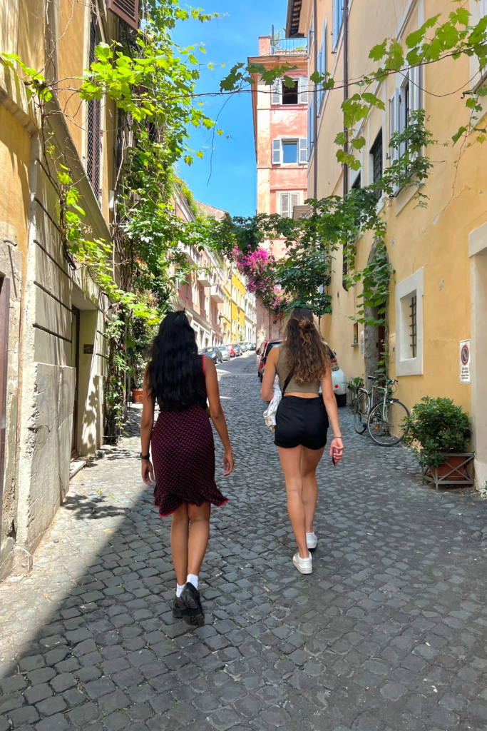 Two friends exploring the hidden and colorful streets of Rome, Italy in the springtime while backpacking Europe