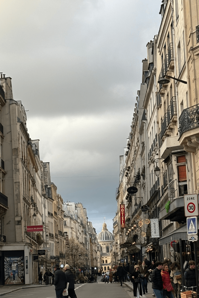 The busy streets of Saint Germain des Près with the Académie Française in the background behind the gorgeous, charming buildings of Paris, France