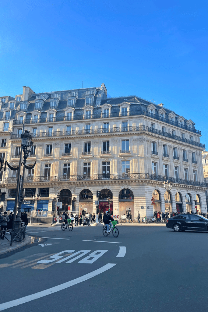 Gorgeous old apartments by the Palais Garnier in Paris on a cool, sunny winter morning with bikers riding by.