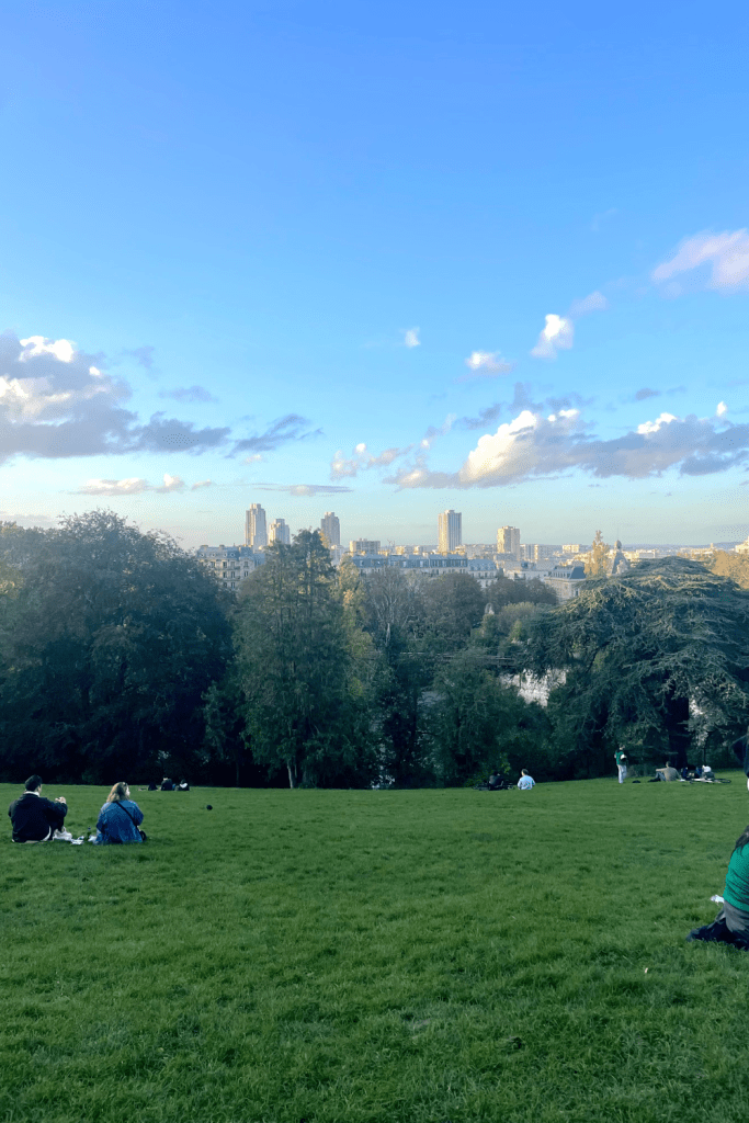 A gorgeous view of the Paris skyline during golden hour from Parc des Buttes-Chaumont on a sunny, fall day.