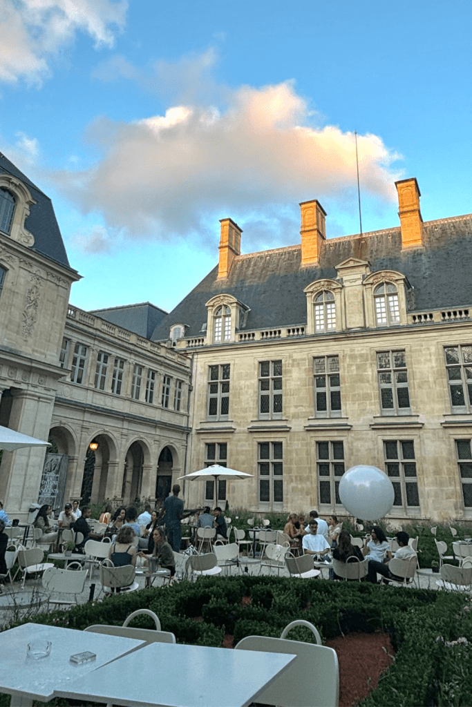 Seasonal bar and restaurant in the courtyard garden of the Musée Carnavalet in Paris in the 3rd arrondissement during golden hour during the summer.