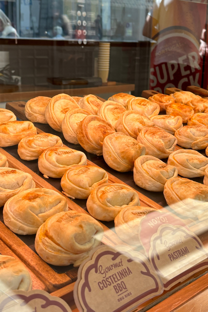 A glass display case of homemade empanadas at a little shop in Porto, Portugal.