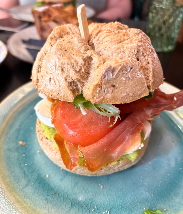 Lunch at an authentic Italian café in Amsterdam, the Netherlands, featuring an Italian sandwich with prosciutto, tomatoes, and avocado.