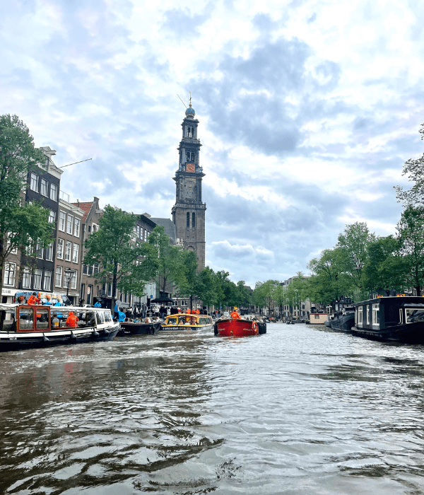 Views of gorgeous gothic and Dutch buildings while taking a canal boat tour in Amsterdam in the Netherlands on a cloudy summer day.