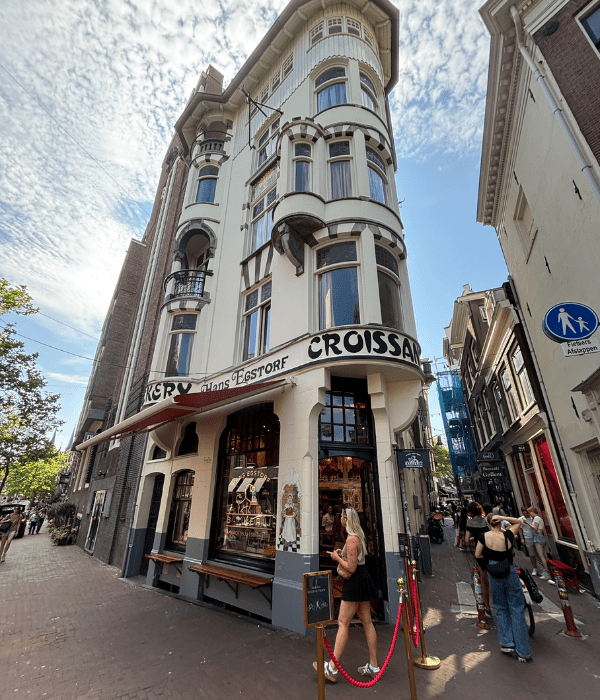 The outside of the oldest bakery in Amsterdam, featuring a narrow building on a sunny day in the summer.