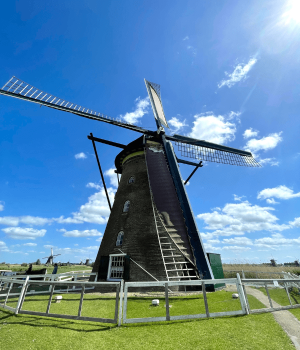 A giant windmill in Kinderdijk in the Netherlands on a beautiful and sunny summer day. This place is recognized as one of the UNESCO World Heritage sites.