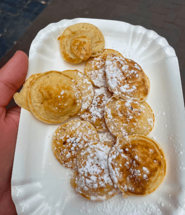 A plate of mini Dutch pancakes, or Poffertjes, in the streets of Amsterdam in the Netherlands
