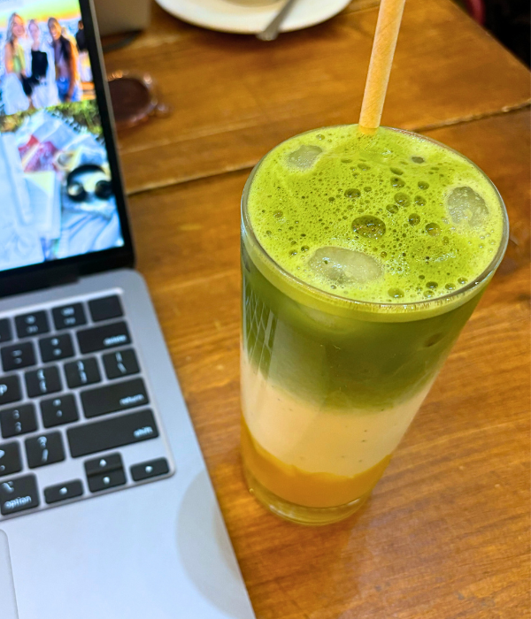 An iced mango latte with mango purée on the bottom, oat milk as the middle layer, and topped with matcha at a café in Paris.